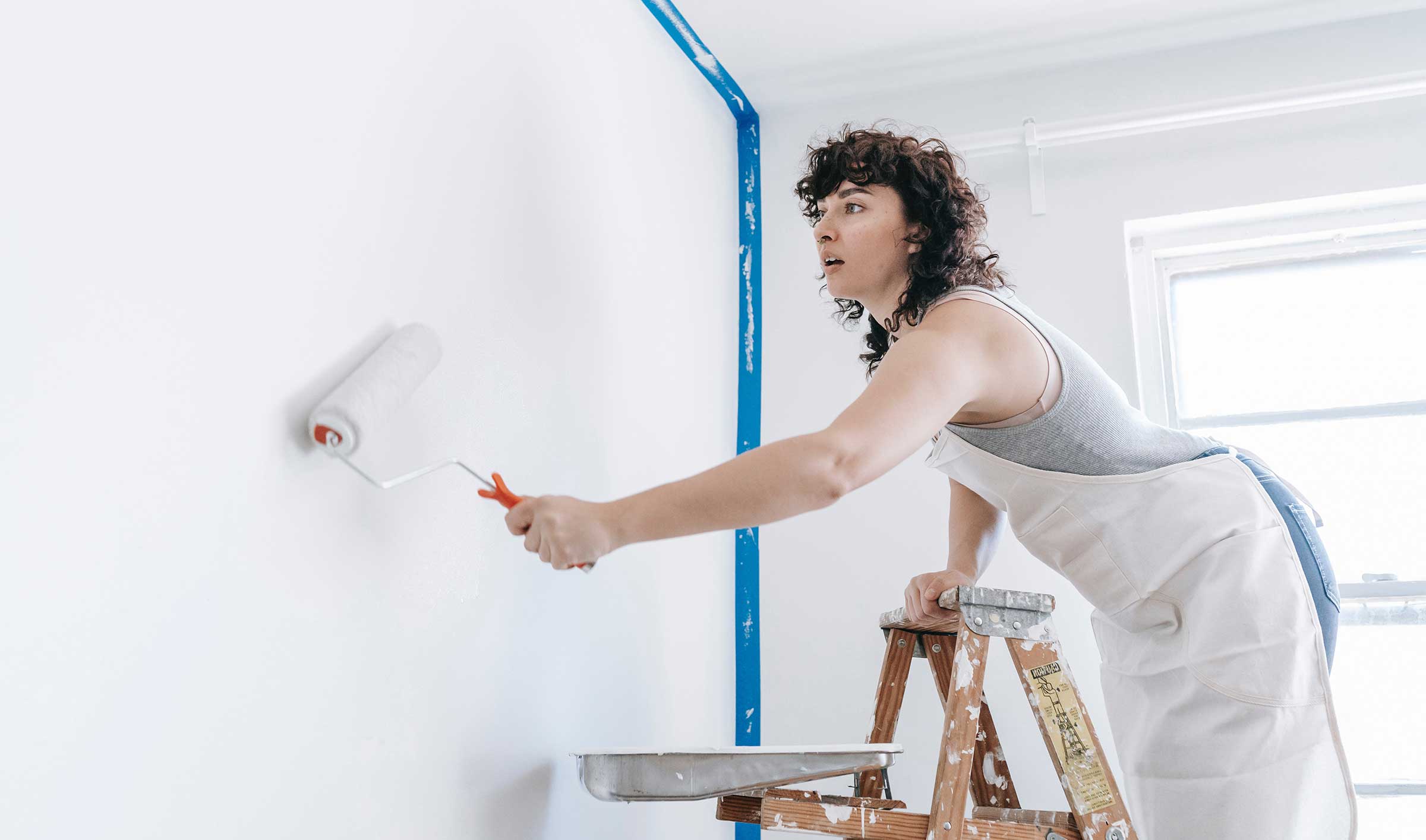 Woman paints walls in her apartment