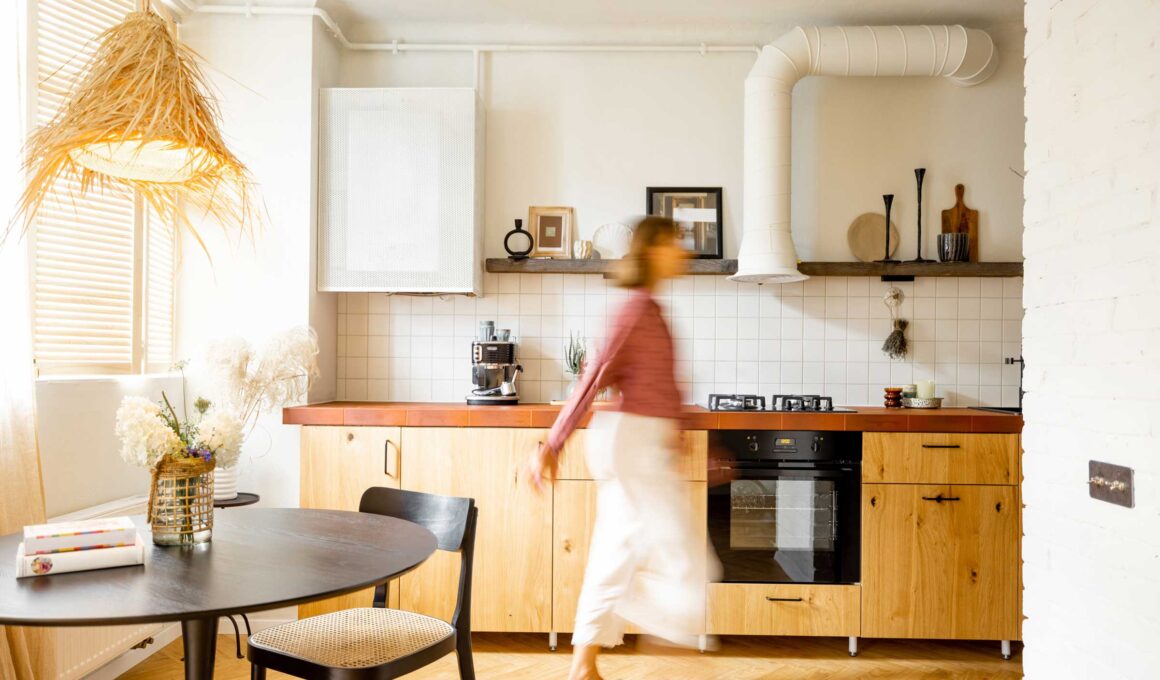 Stylish kitchen interior of modern apartment with motion blurred female person walking inside.