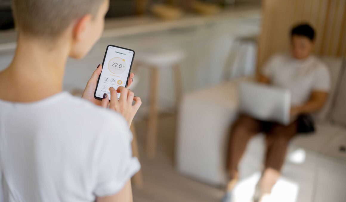 Man and woman controlling heating system with mobile app at home.